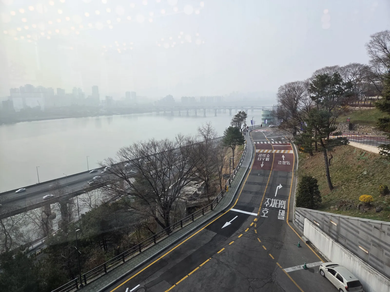 창문 너머로 보이는 안개 낀 한강 전경