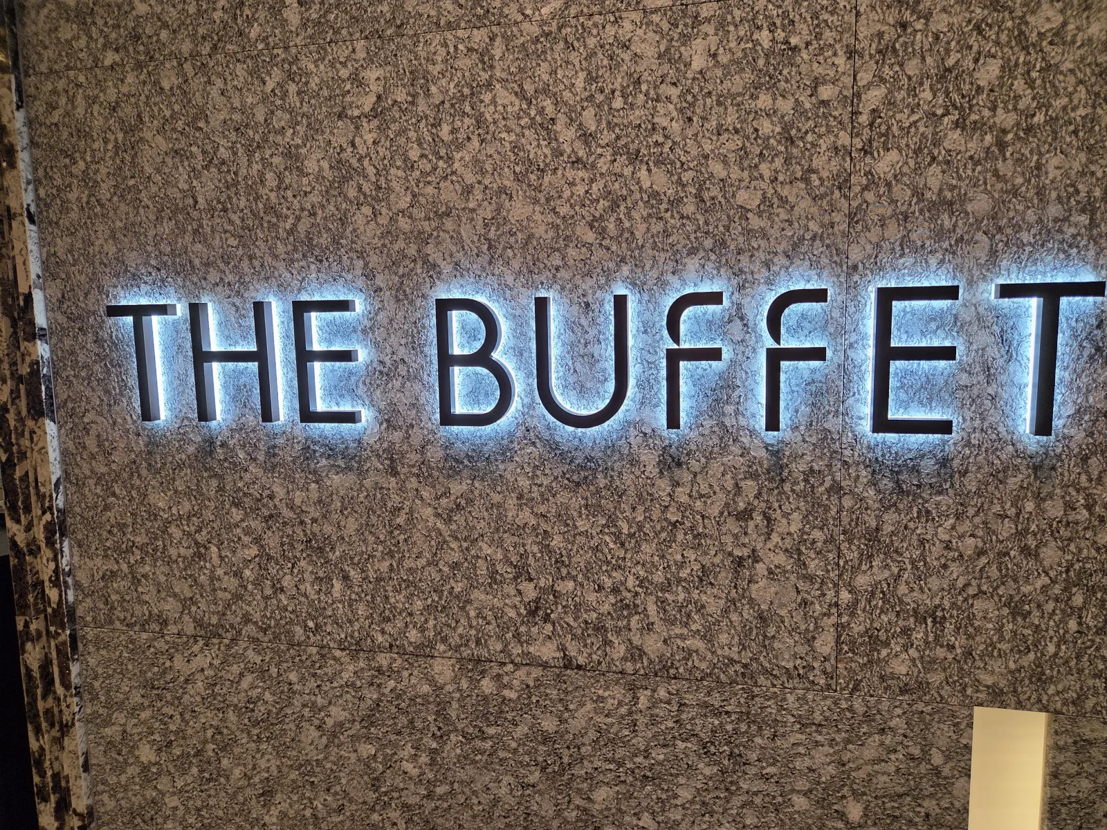 화강암 벽에 설치된 THE BUFFET 네온 간판