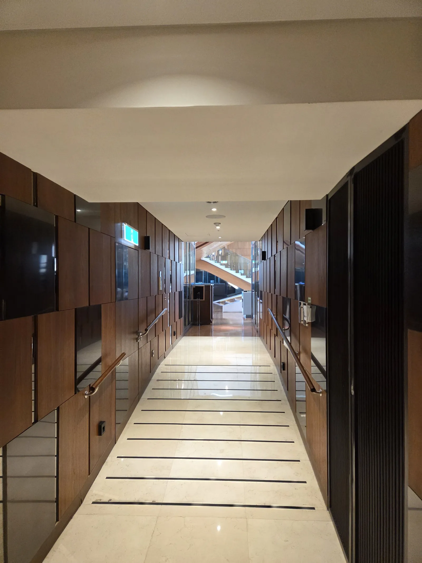 LUXE BAR 진입 통로 우드톤 바닥과 대리석 벽면