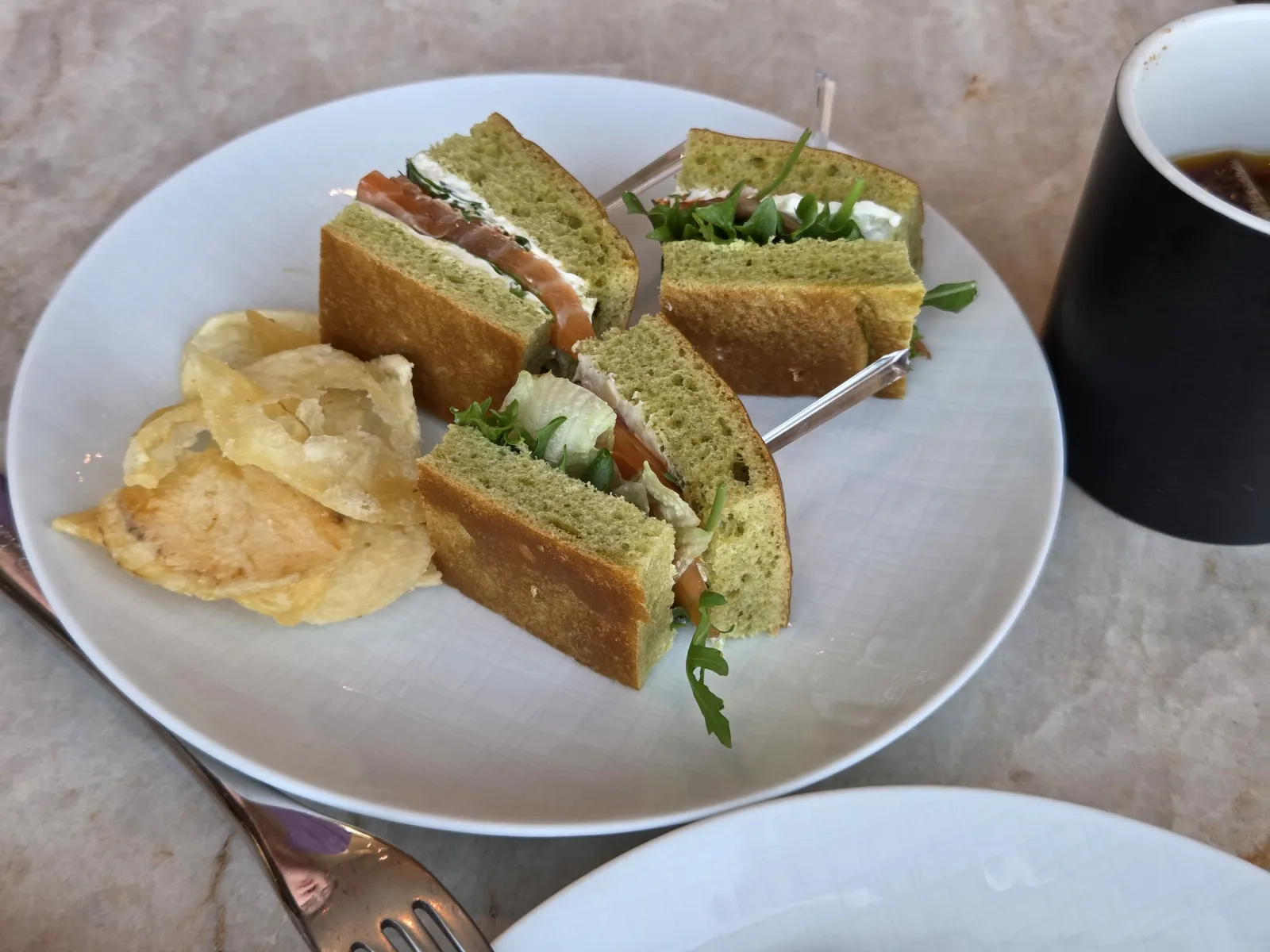 접시에 담은 연어 샌드위치와 트러플 감자칩 커피