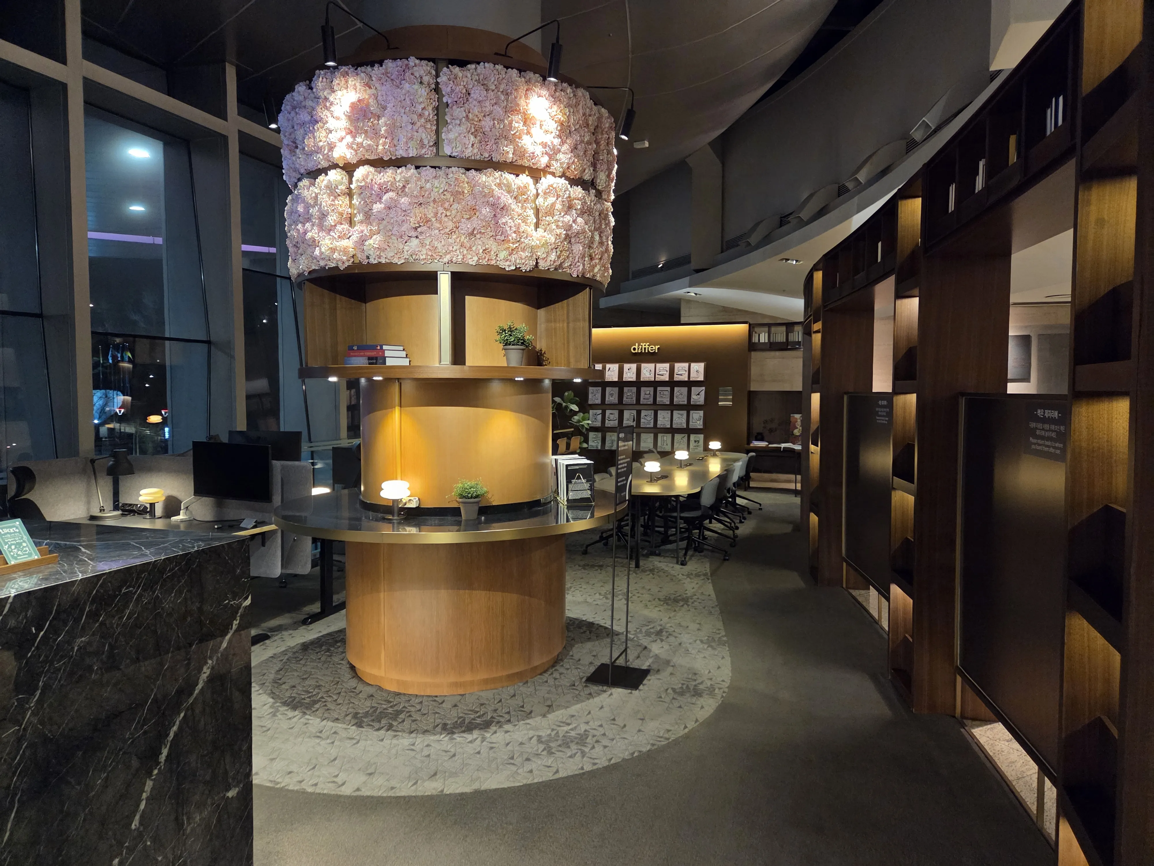 라이브러리 중앙 원형 데스크와 꽃 샹들리에 업무 공간